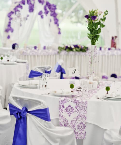 Beautiful wedding set decoration in the restaurant. Chairs with Beautiful wedding set decoration in the restaurant. Chairs with violet ribbons.